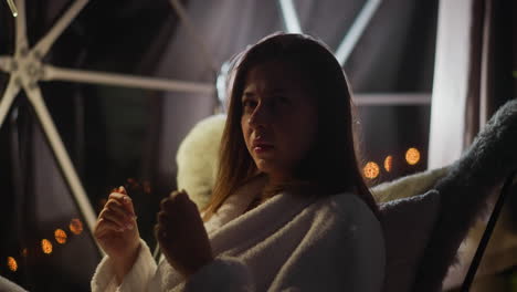 pensive woman in bad mood yawns looking away on transparent terrace with subdued lighting. frustrated lady feels depressed and lonely thinking about troubles