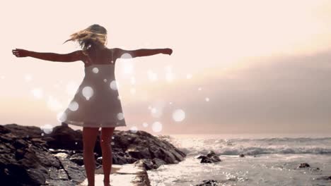 mujer joven bailando en la orilla de la playa con efecto de luz