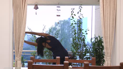 indian woman doing yoga stretches in the morning on her terrace