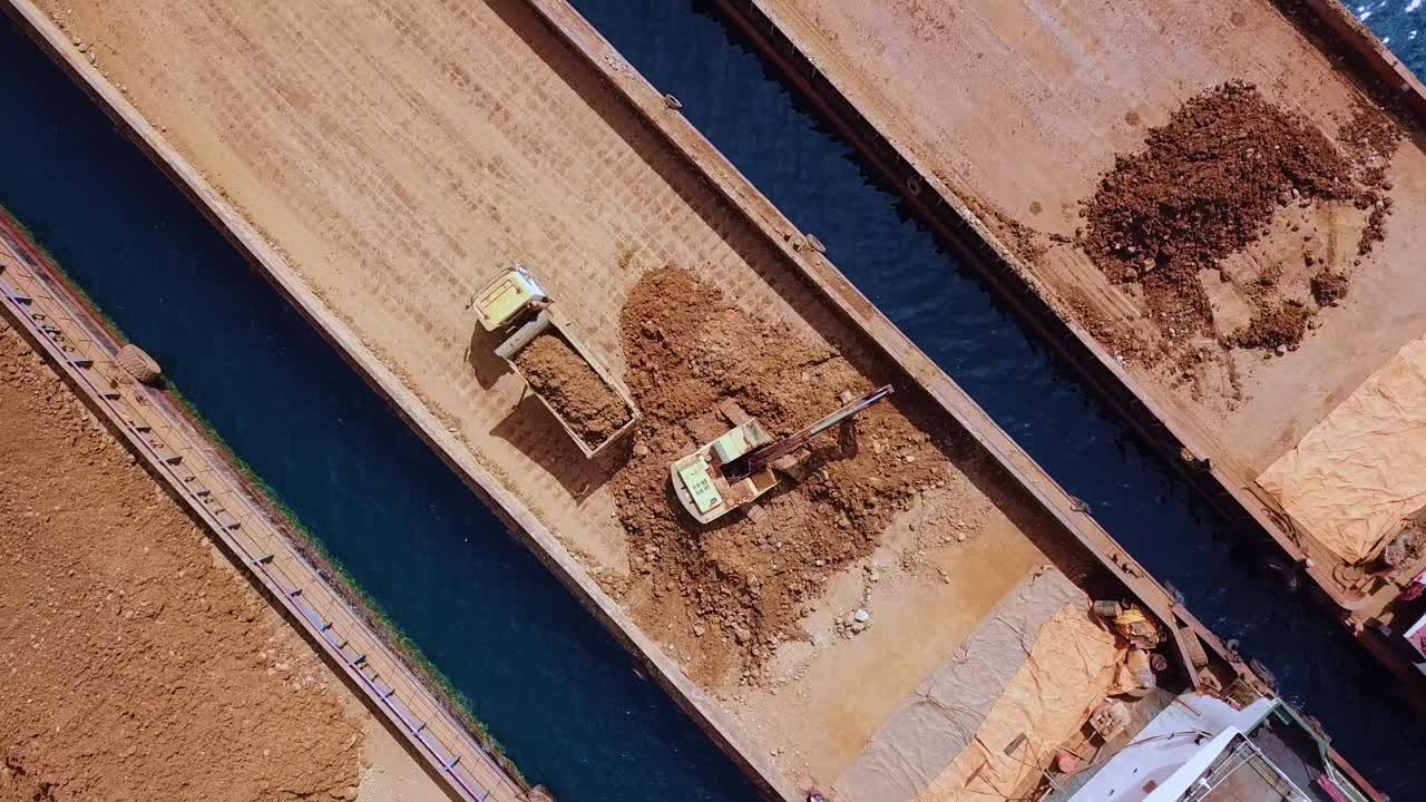 vista aérea de una excavadora trabajando con un camión para un proyecto minero en la isla de hinatuan, filipinas