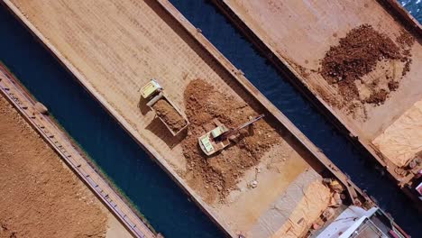 aerial view of excavator working with truck for mining project at hinatuan island, philippines