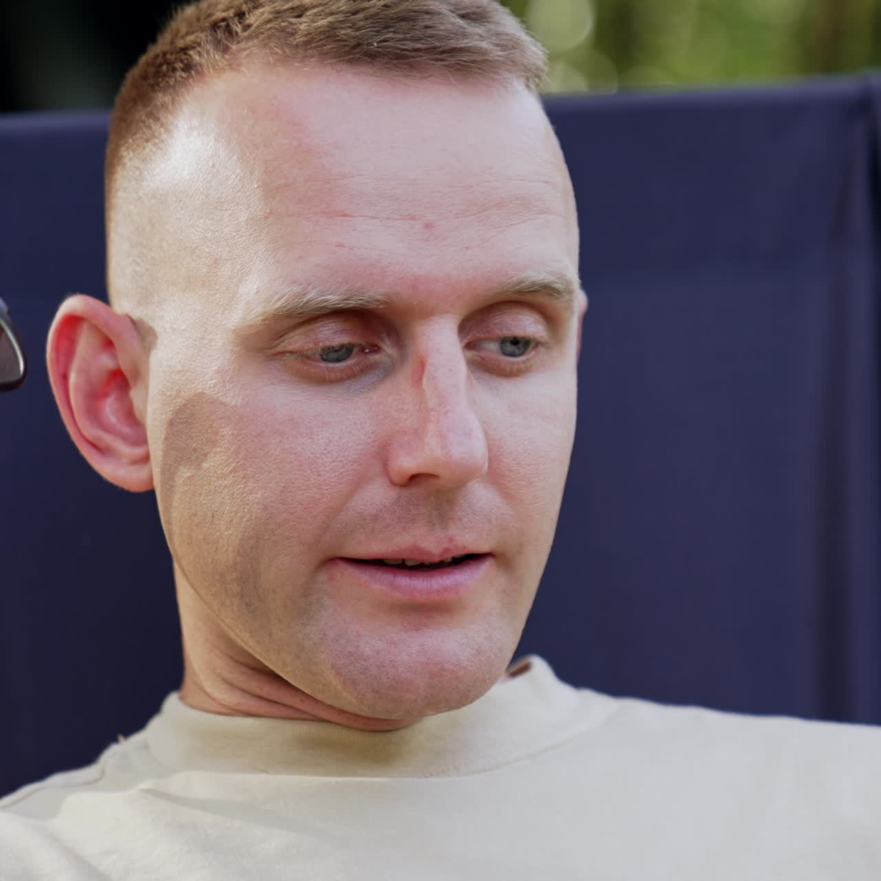 Puzzled man looks at laptop screen waving head disapprovingly. Freelancer working outdoors having some difficulties in work