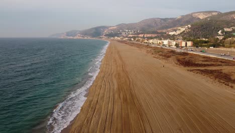 Larga-Playa-De-Arena-De-Castelldefels-En-Barcelona,-Olas-Golpeando-Suavemente-La-Orilla,-Vista-Aérea