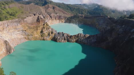 drone shot on top of a volcanic lagoon of mount kelimutu at flores island, indonesia