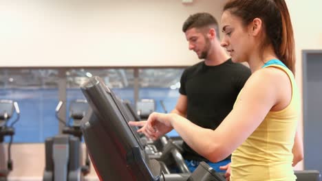 couple using the treadmills in gym