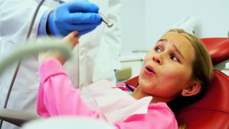 Girl-stopping-dentist-for-examining-her-in-clinic