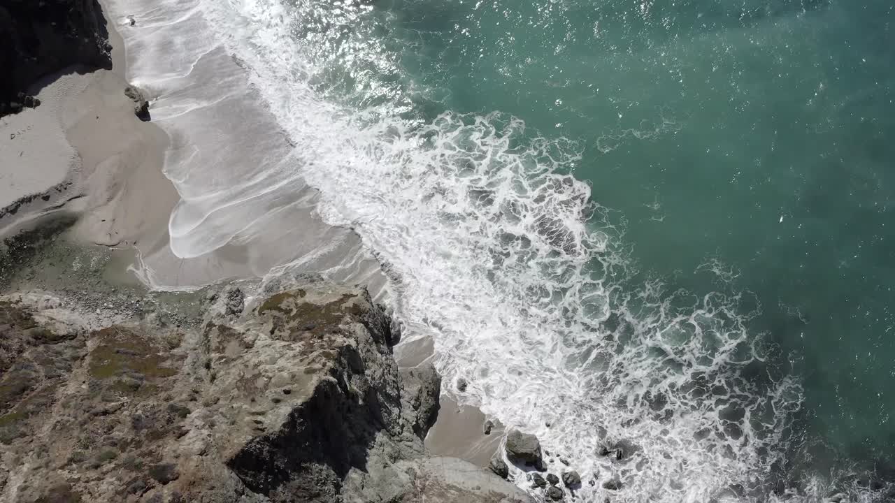 Costa frastagliata del Big Sur californiano, onde che si infrangono contro la battigia, aerea