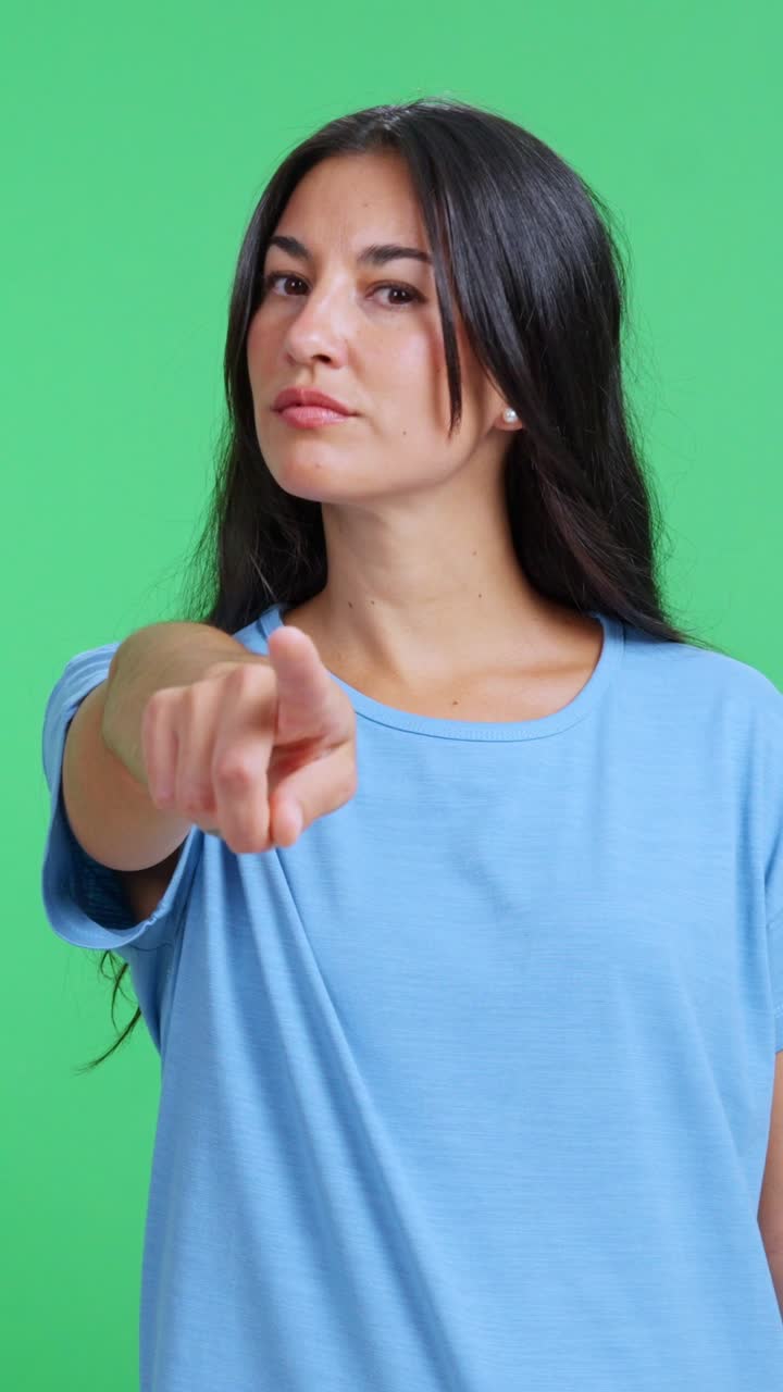 Donna seria che punta il dito indicandoti in studio.
