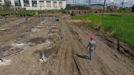 engineer in orange helmet walks. technical expert is walking to the construction of a new solar power plant on the field. top view.