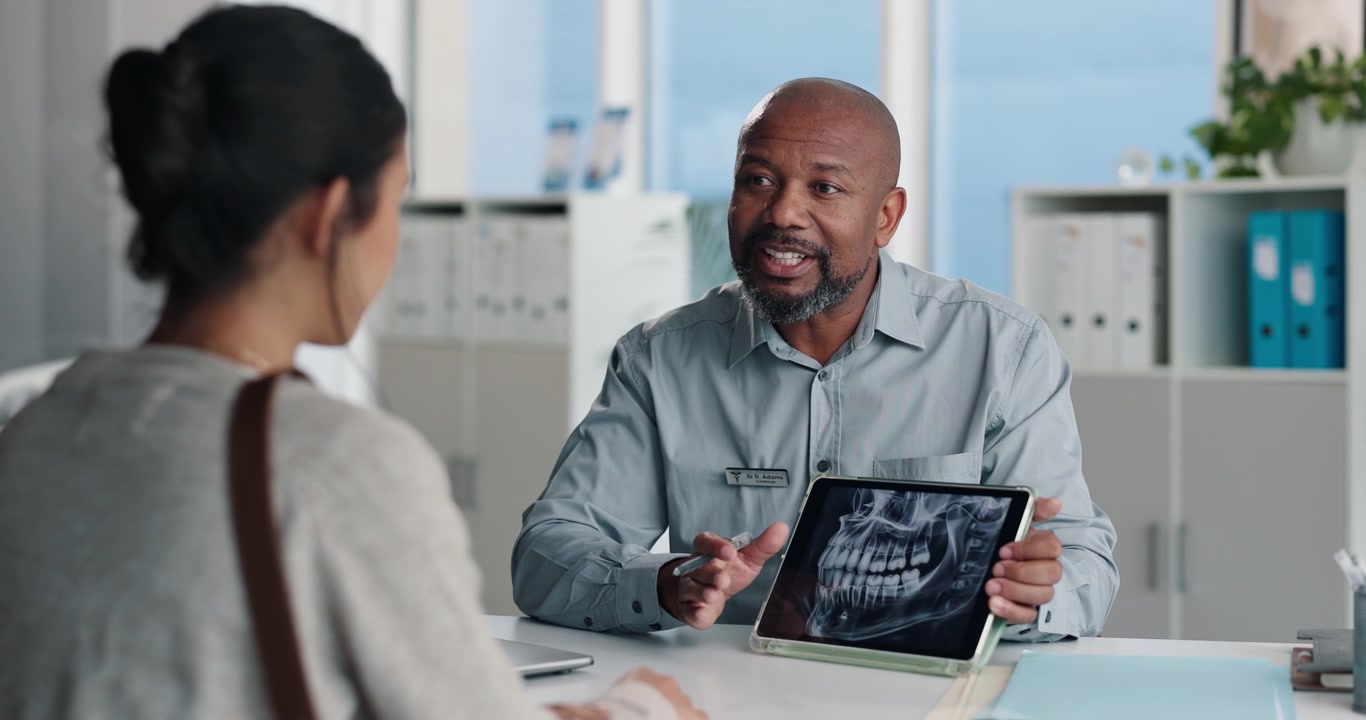 Dentist Explaining Dental X-ray to Patient on Tablet