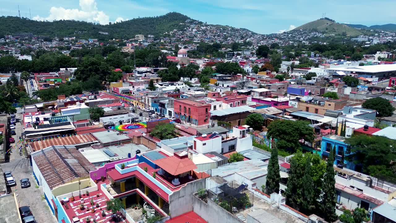 Drone aerial landscape of streets in Oaxaca old town city suburbs including residential housing buildings apartments cars driving Mexico mountain hill travel tourism