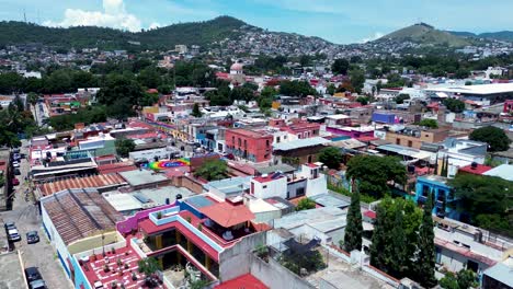 drone aerial landscape of streets in oaxaca old town city suburbs including residential housing buildings apartments cars driving mexico mountain hill travel tourism