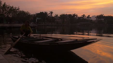 Dame-Auf-Einem-Traditionellen-Vietnamesischen-Boot-Bei-Sonnenuntergang