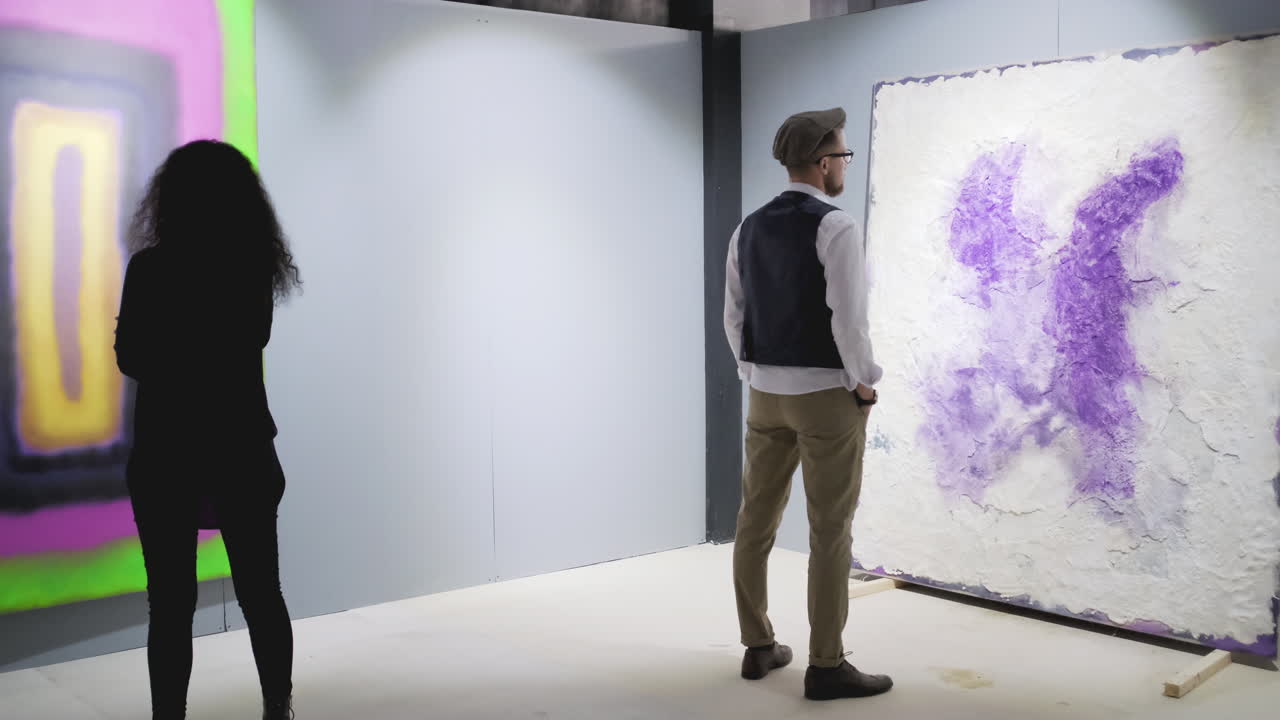 visitantes de galerías de arte viendo pinturas abstractas