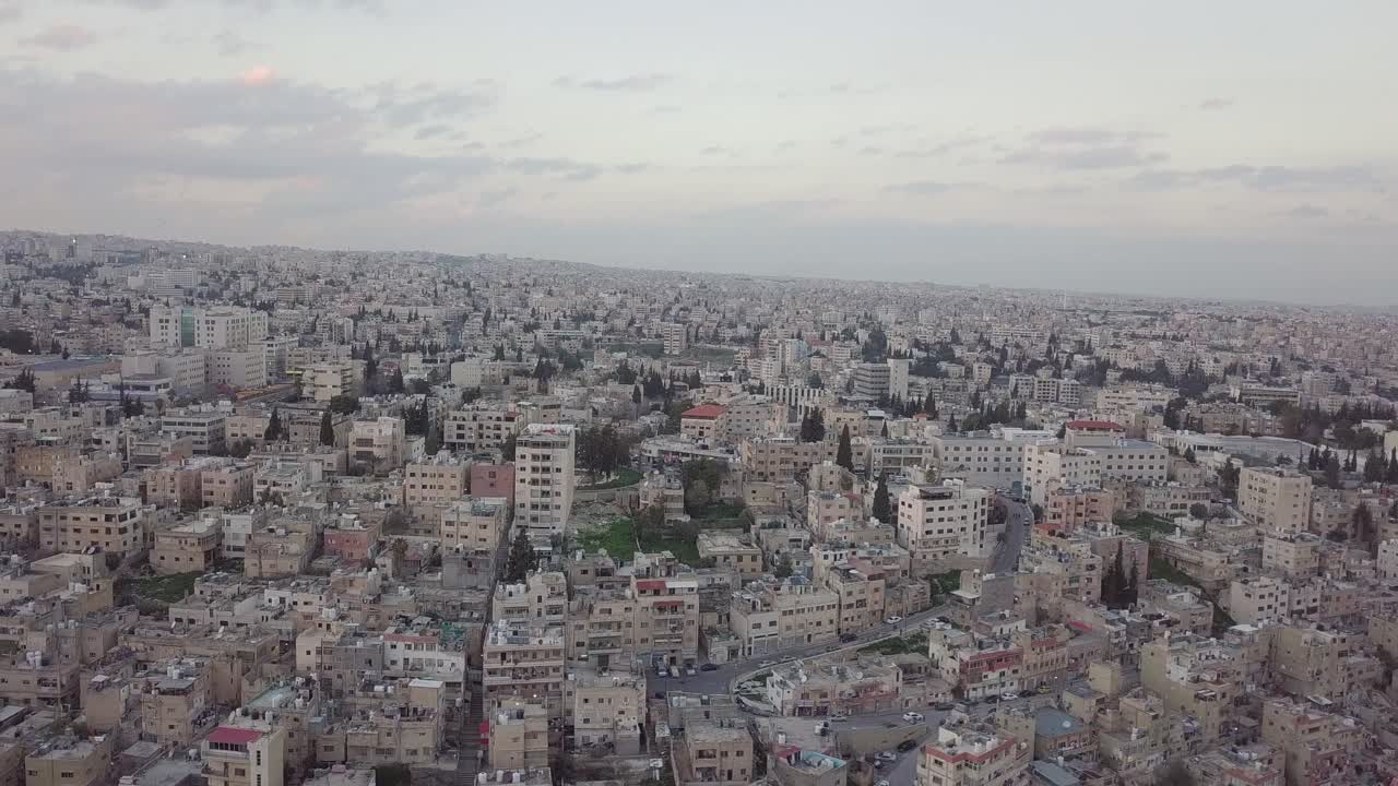 serena madrugada en amman jordania tomada por un dron que desciende lentamente y se mueve con una bandada de palomas volando