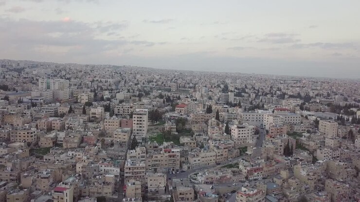 Alba serena ad Amman, Giordania, ripresa da un drone che scende lentamente e si muove con uno stormo di piccioni in volo