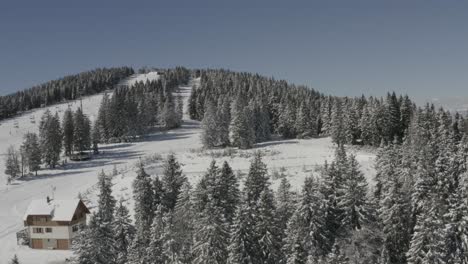 Acercándose-Al-Lago-De-Captación-De-Agua-De-Lluvia-En-La-Estación-De-Esquí-De-Kope-En-Eslovenia-Durante-El-Invierno,-Tiro-De-Aproximación-Aérea