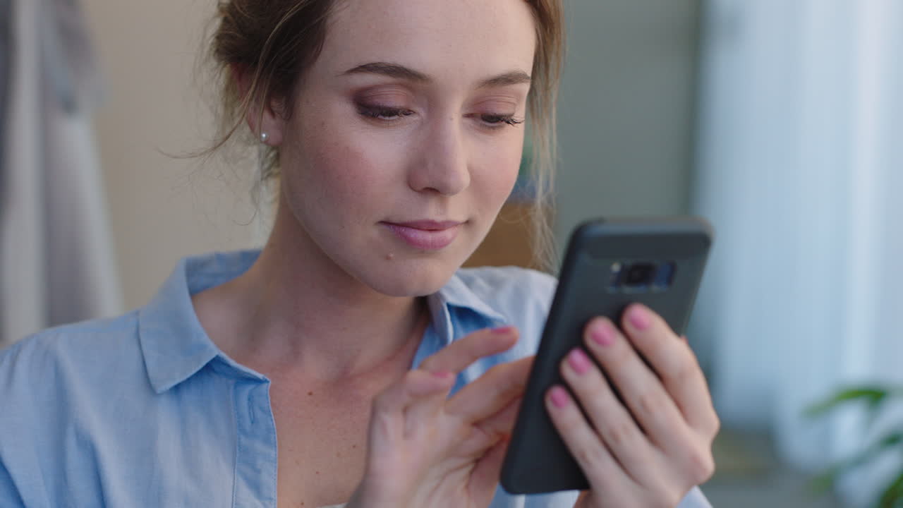 mujer hermosa usando un teléfono inteligente enviando mensajes de texto navegando por los mensajes de las redes sociales disfrutando de la comunicación por teléfono móvil en casa