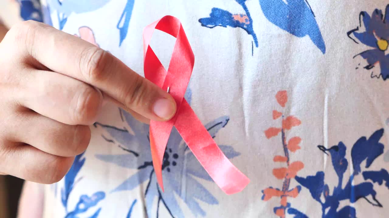 mujer sosteniendo una cinta de conciencia roja