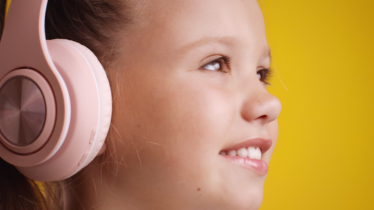 chica escuchando música con auriculares rosados