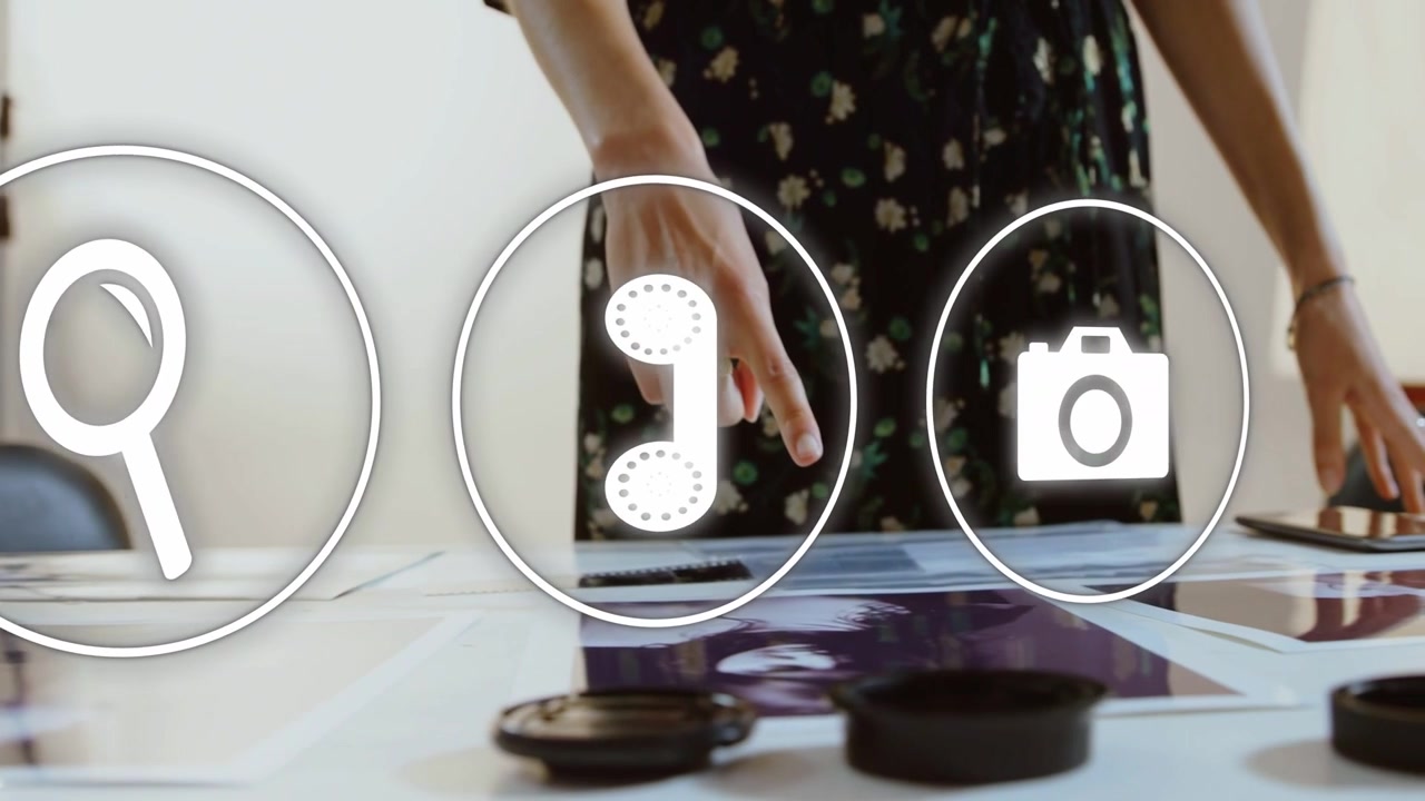 Female creative hovering hand over prints, activating faint icons and tapping phone selecting tools