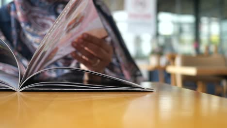 woman reading a magazine in a cafe