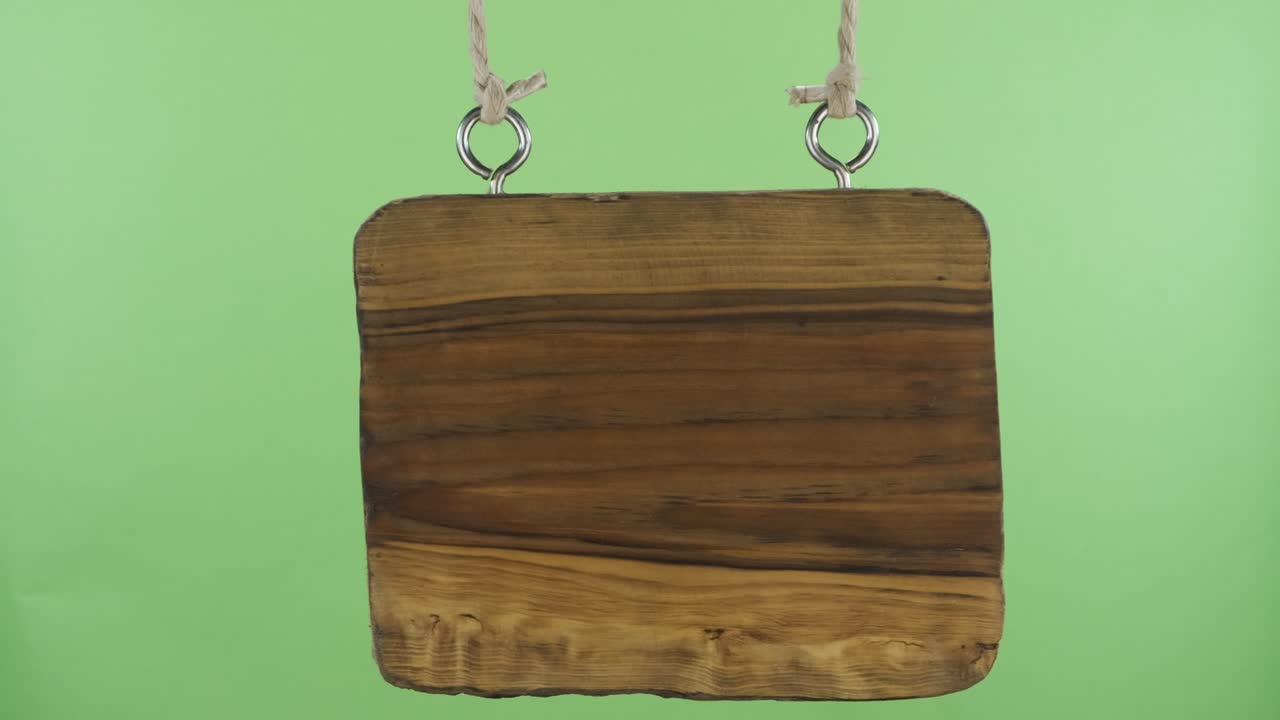 은 빈 나무 표지판이 으로 흔들립니다. 녹색 화면.