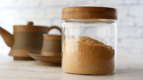 brown sugar in glass jar with teapot and cup