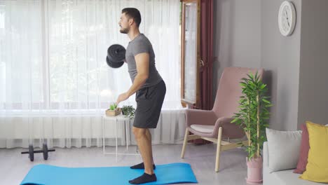 Hombre-Haciendo-Ejercicios-En-La-Sala-De-Estar-De-Casa-Y-Trabajando-Músculos-Con-Pesas-Pesadas.