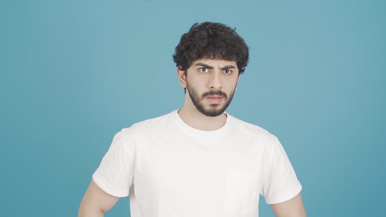 Frustrated young man looking at camera angrily.