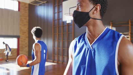 portrait of african american male basketball player wearing face mask with team