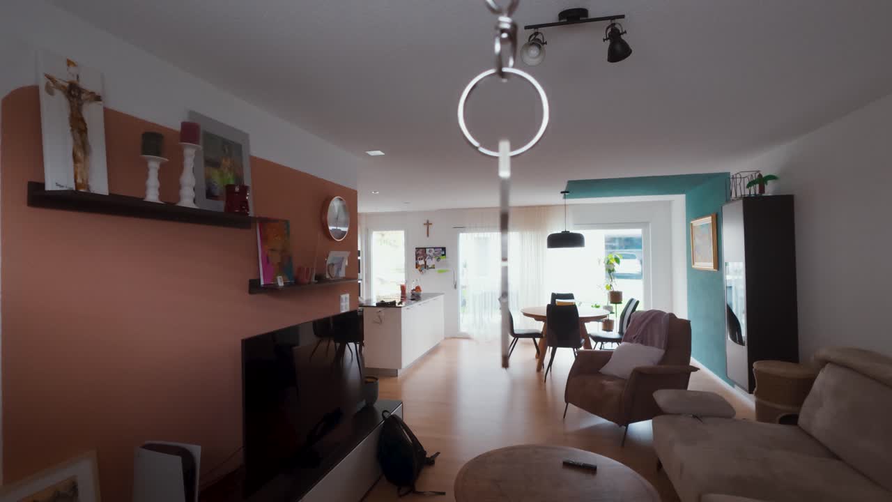 A shiny apartment key appears suspended in the air inside a bright modern living room. Perfect for real estate, renting, home ownership, or property marketing concepts