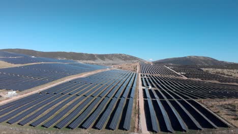 Drone-Sobre-Enormes-Colinas-De-Paneles-De-Hilera-De-Parques-De-Energía-Solar-Fotovoltaica-Panorámicas-Hacia-Abajo