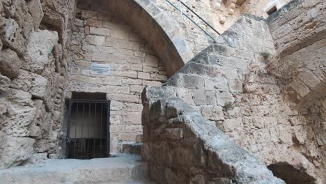 Climbing-old-romanesque-stairs-leading-to-the-Kyrenia-castle-ramparts---Wide-gimbal-push-in-shot