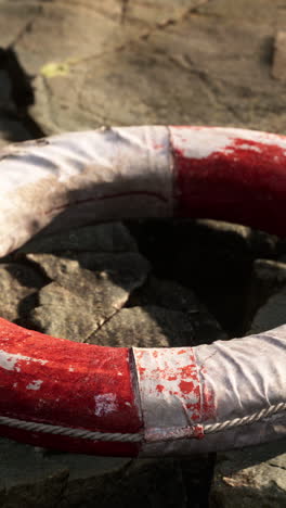 old lifebuoy on a rocky ground