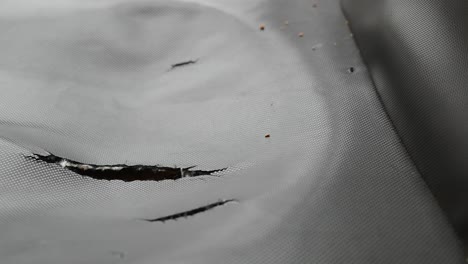 close-up of torn grey mesh fabric