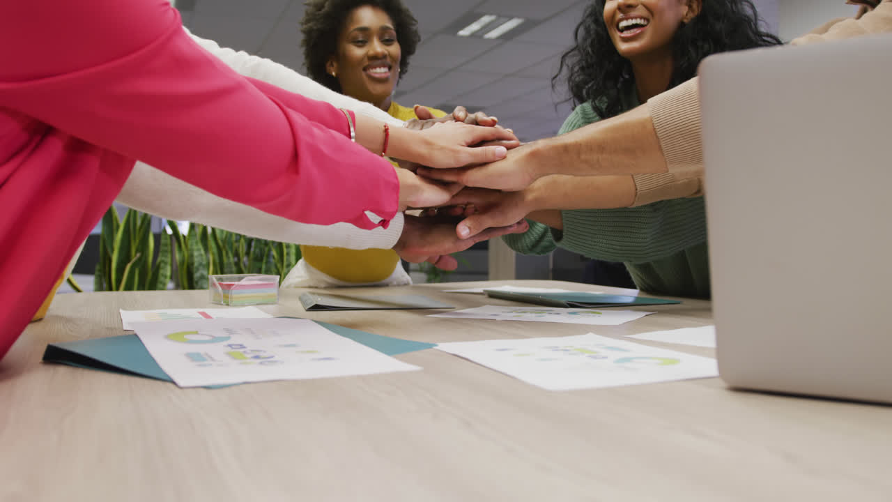 Happy diverse male and female business colleagues teaming up in office
