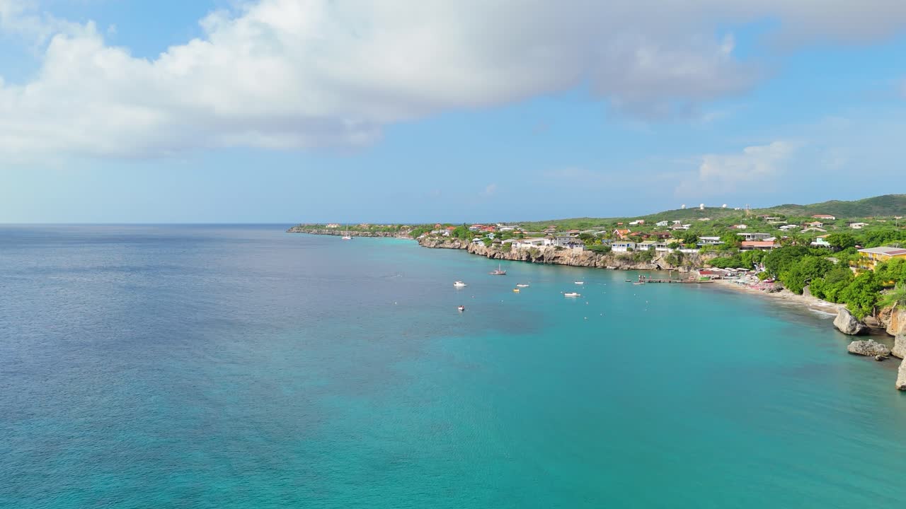 Ripresa in dolly con drone lungo le scogliere rocciose verso Playa Piskado in una bella giornata di sole