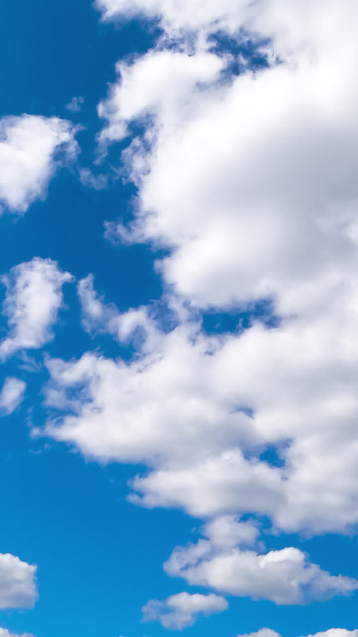 Bright amazing azure skies with beautiful cumulus clouds quickly changing shapes. Quick cloud transformation timelapse. Vertical video
