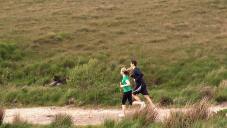 athletic couple jogging in the countryside together