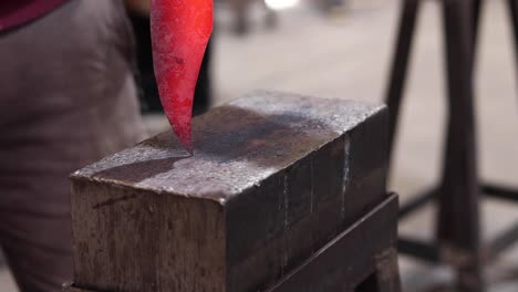 schmiede, die heißes metall mit hammer in der werkstatt schmieden