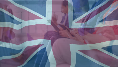 Animation-of-flag-of-uk-and-data-processing-over-diverse-business-people-using-tablets