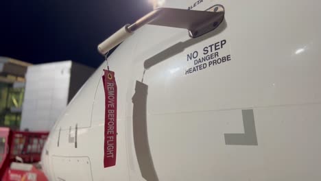 close view of a medium size jet, with pitot cover and “remove before flght” red label waving