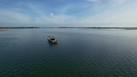 fishing-boat-floating-in-calm-ocean-at-golden