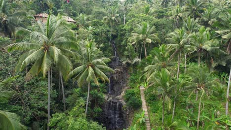 Aerial-Approaching-Gembleng-Waterfall-in-Sidemen-Village,-People-Bathing-in-Infinity-style-Rock-Pools-of-Small-Waterfall-Cascades-in-Tropical-Jungle-of-Bali-Indonesia