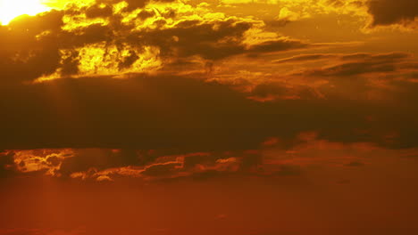 Time-lapse-moving-clouds-over-bright-orange-yellow-sun-at-sunset-sunrise