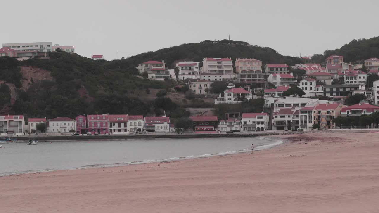 paisaje panorámico de hermosos edificios antiguos en la ladera cerca de una playa en sao martinho do porto en portugal - plano amplio