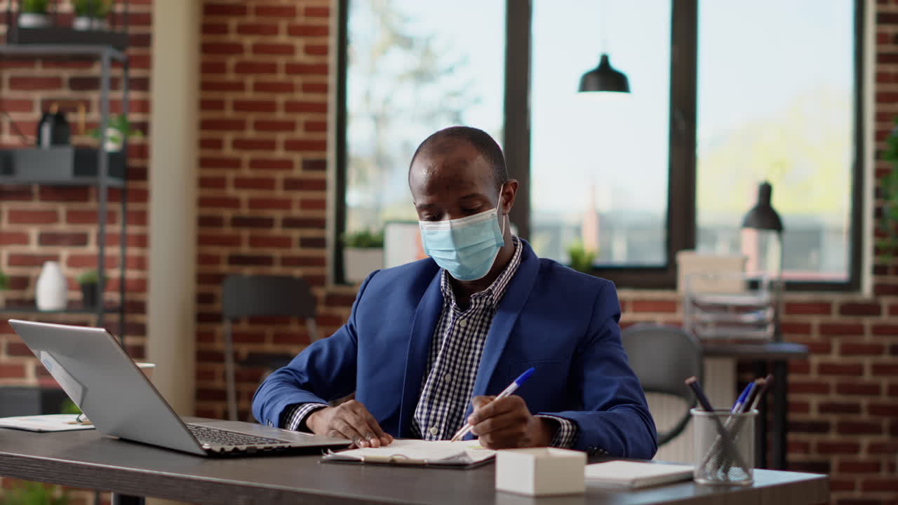 Businessman taking notes on company paperwork