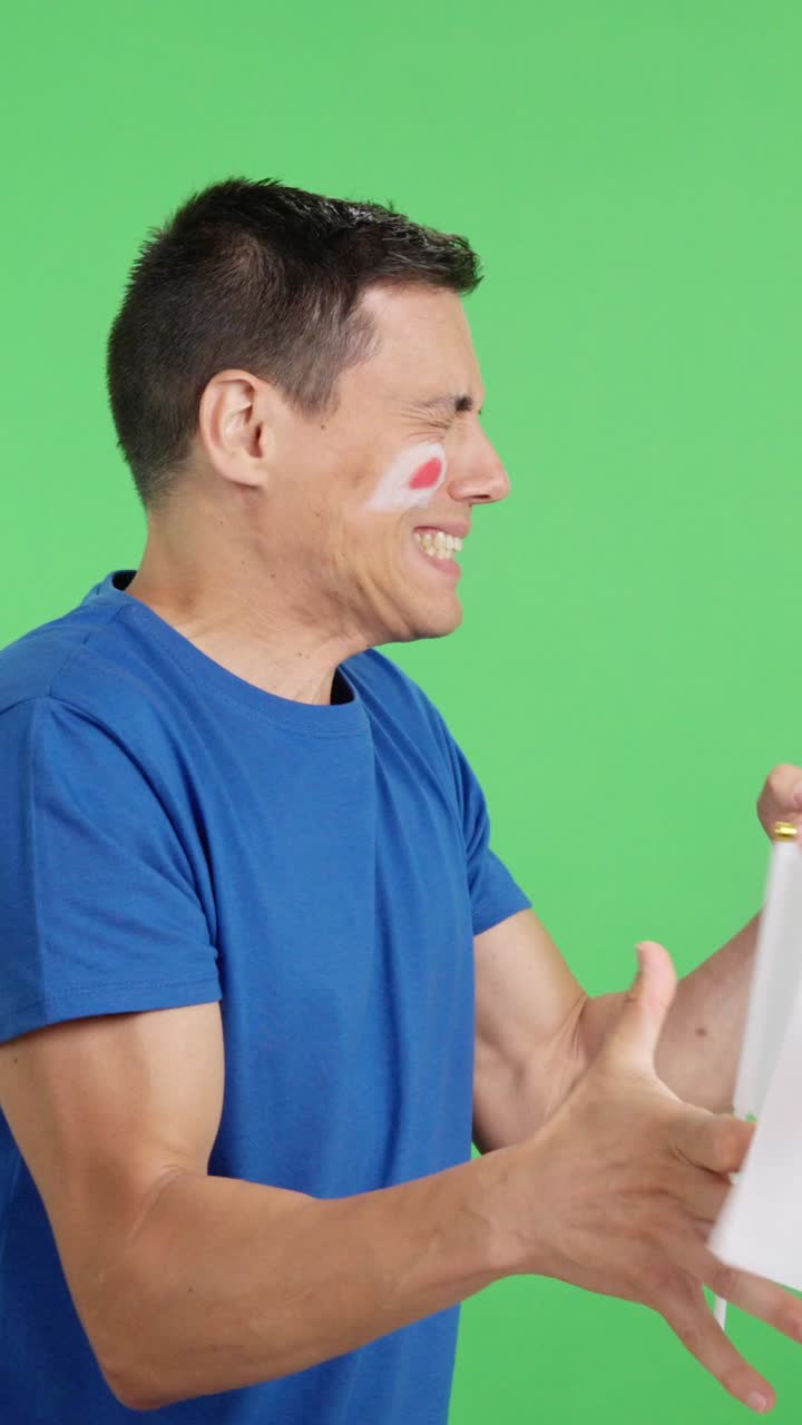 Nervous man cheering for Japan during a match looking away