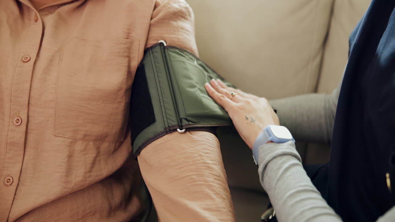 Caregiver Attaching Blood Pressure Cuff to Patient's Arm